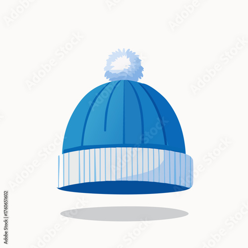 Blue winter hat with white brim and pompom, isolated on white background.