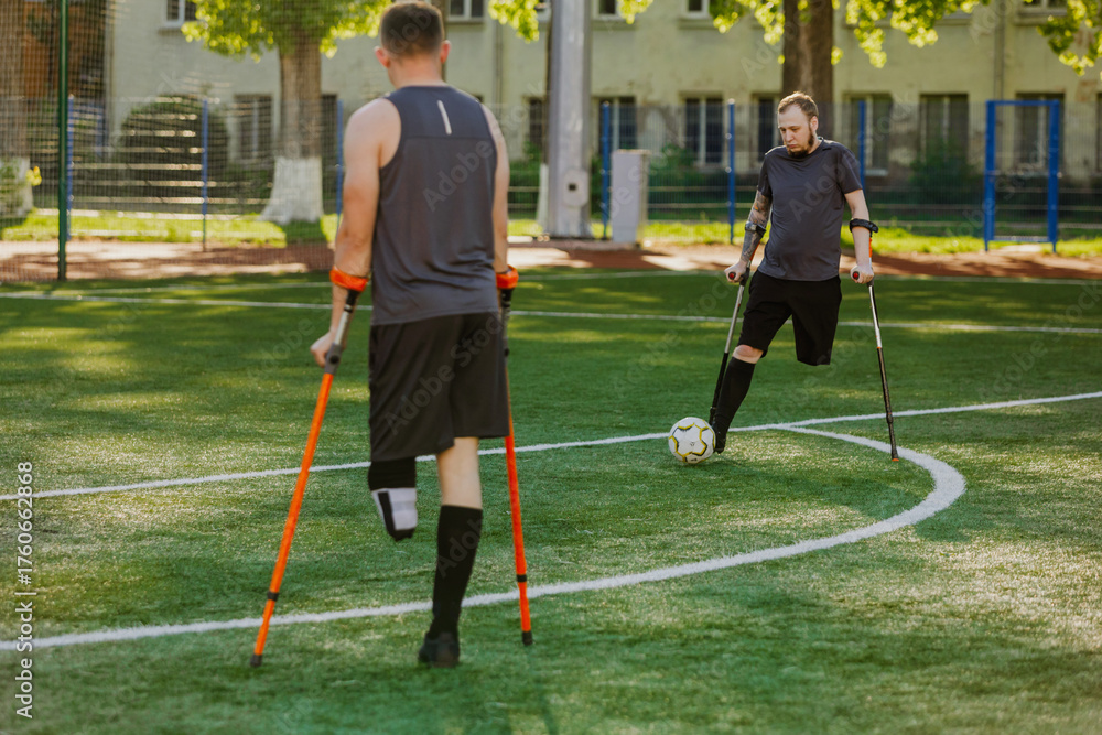 Obraz premium A man dribbles a ball to a man standing next to him while they hold crutches