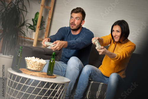Young couple playing video games at home