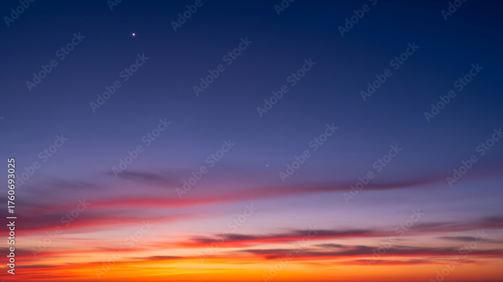 Obraz premium Vibrant sunset sky with distant moon and clouds