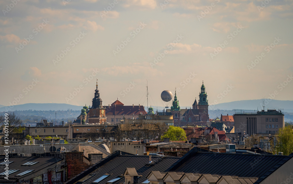 Obraz premium Historic Krakow skyline with iconic towers, rooftops, and distant hills under a clear sky. A perfect cityscape view of Poland's cultural heart.
