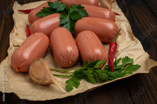 Photography Fresh Vienna Sausages with Garlic, Red Chili Peppers, and Parsley on Rustic Pape