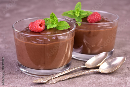 Chocolate mousse with raspberries in glass cups on a gray background.Close-up.
