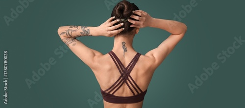 Tattooed young woman on gre...