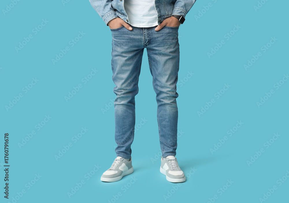 Fototapeta premium Stylish man in jeans and denim jacket on blue background