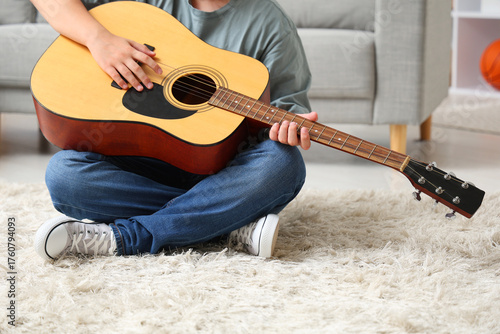 Teenage boy playing guitar ...