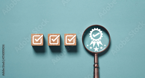Wooden blocks with check marks and magnifying glass showing quality assurance badge symbol representing product certification standard control and business excellence concept