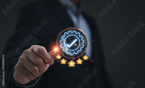 Businessman hand holding magnifying glass with glowing check mark and five stars symbolizing quality assurance customer satisfaction service excellence and business success on dark background