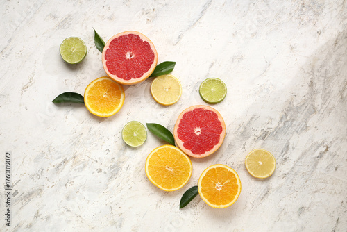 Fototapeta Naklejka Na Ścianę i Meble -  Slices of tasty citrus fruits on marble background