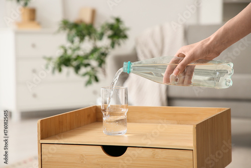 Young woman pouring water f...