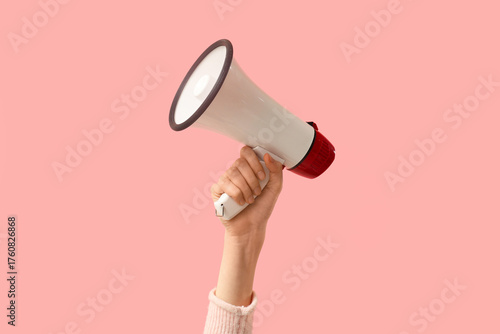 Obraz na płótnie Female hand holding megaphone on pink background