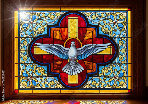 Intricate stained glass window with a white dove of peace and a cross, illuminated by a bright sunbeam.