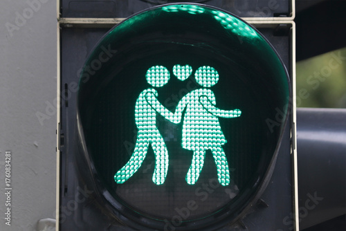 Close-up of the green light figure of a couple holding their hands.