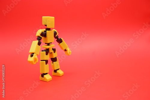 Yellow Poseable Action Figure on Red Background