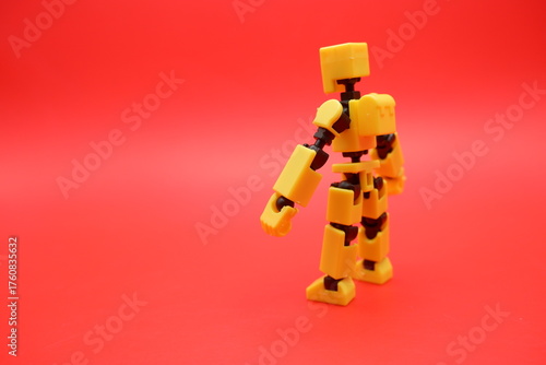 Yellow Poseable Action Figure on Red Background