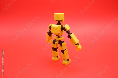Yellow Poseable Action Figure on Red Background
