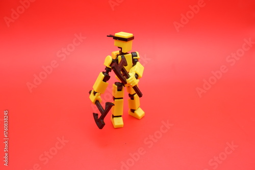 Yellow Action Figure Holding Dual Axes on Red Background