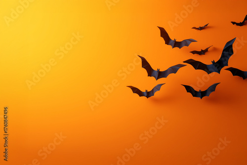 Halloween-style background with bats. Paper bats on an orange background. 