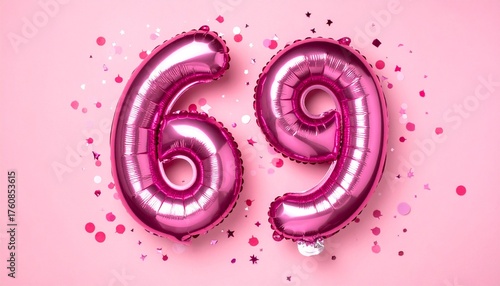 Pink balloon number 69 with confetti on solid colored background. Photo for anniversary or birthday party