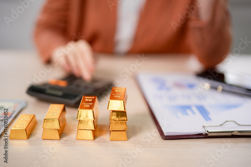 Fotografija Adult investor analyzes gold investment calculations financial growth wealth man