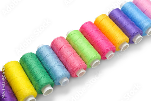 Row of colorful thread spoo...