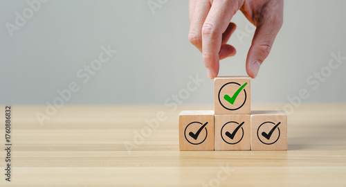 Checklist and quality assurance concept with wooden blocks stacked with check mark icons, symbolizing task completion, project approval, business standard, successful evaluation, process verification