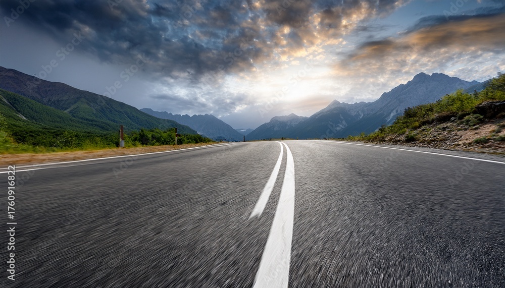 Naklejka premium open asphalt road leading to mountains under a cloudy sky showing tire marks and surface details