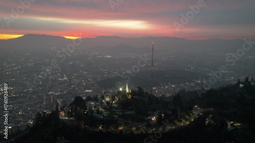 Atardecer cerro san cristóbal con la virgen iluminada, vista aérea desde Dron