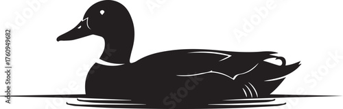 Silhouette of a black duck swimming gracefully on calm water surface with ripples