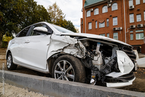 front side view of crashed white car from accident