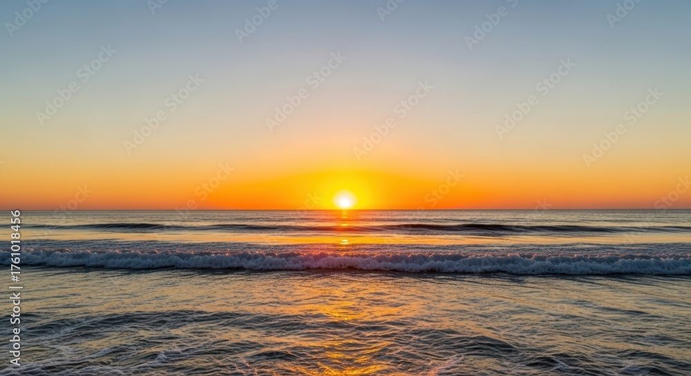 Obraz premium Sunset over ocean waves with vibrant orange sky