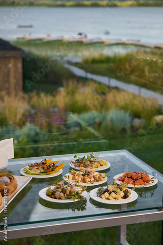 A Beautiful Outdoor Spread of Exquisite Gourmet Plates Set by the Water, Perfect for Enjoyment
