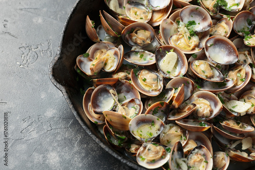 Steamed Clams with garlic, parsley and white wine in a cast iron pan