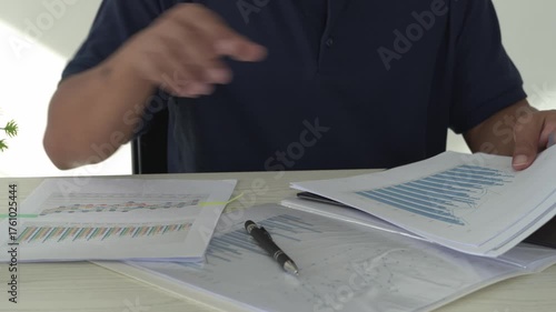 Focused young asian man reading and checking paper documents, signing the contract to send to her business partner. Concentrated smart ambitious businessman is organizing the paper works.