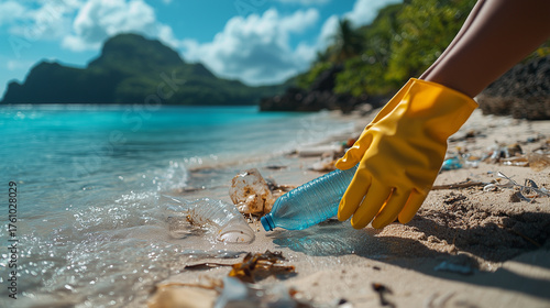 Person collecting plastic bottle from beach during sunny day