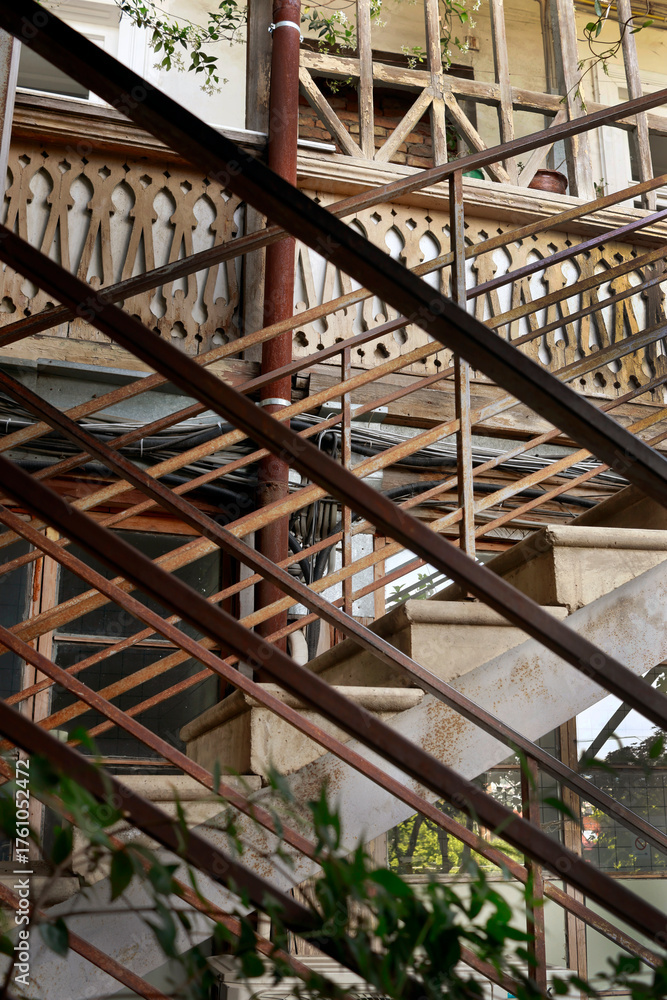 Obraz premium Traditional wooden balconies with carved railings in the historic district of Tbilisi, Georgia. Warm sunlight highlights the charm and cozy atmosphere of the old town.