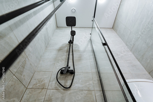 modern shower design, contemporary bathroom featuring tall tiled walls and rain shower, elegant bathroom setup with vertical perspective emphasizing rain fixture and modern scale