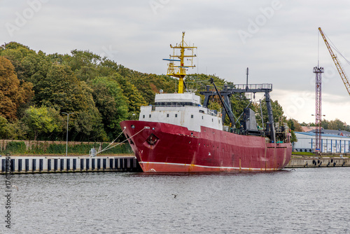 Large Red Cargo Vessel Docked in an Industrial Port