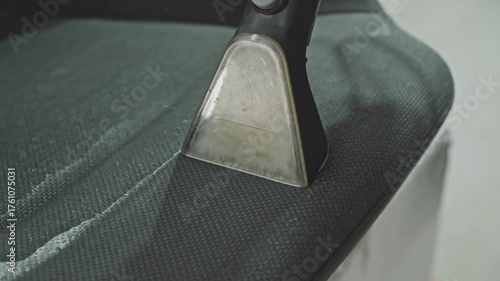 Person cleaning car seat using washing vacuum cleaner. Watch as dirt and stains disappear from car seats, revealing a fresh and clean interior. Transforming dirty car seats. Close-up in 4K, UHD
