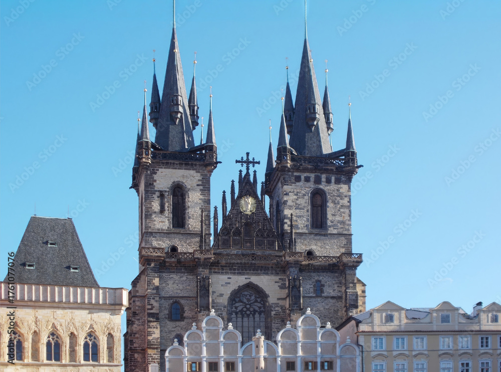 Fototapeta premium Gothic Tyn Church in Prague against clear blue sky, expressive spires and medieval stonework create dramatic urban silhouette