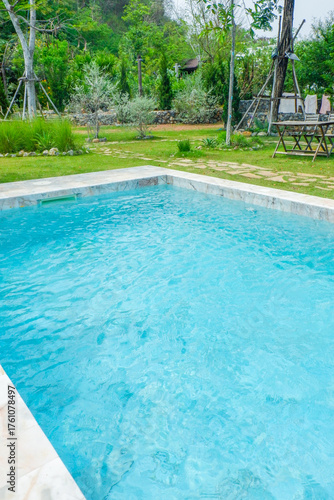 Empty swimming pool with sunbed and white umbrella in resort hotel for vacation leisure and white sand,resort neary sea and beach in summer.