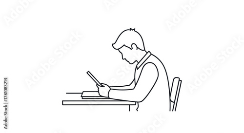 Young man engrossed in reading a tablet at a desk.