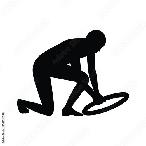 Silhouette of person holding ring, kneeling in an athletic stance ready to start