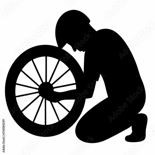 Silhouette of a man repairing a bicycle wheel, kneeling and concentrating