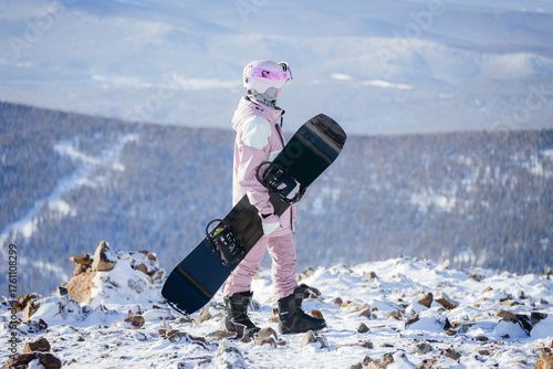 a girl in a pink ski suit on the top of a mountain