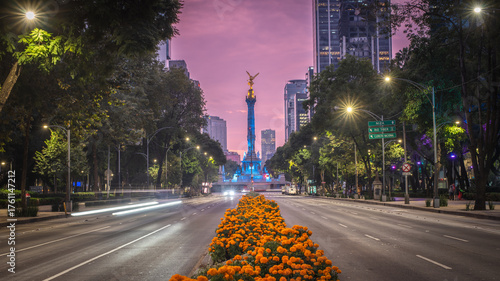 Fototapeta Naklejka Na Ścianę i Meble -  Avenida Paseo de la Reforma in Mexico City, adorned with bright orange marigold (cempazuchil) flowers in the medians, leading the eye to the iconic Angel of Independence monument. Day of dead.