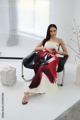 A female model in a light dress poses in a modern interior