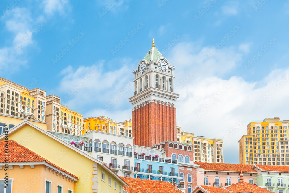 Fototapeta premium Colorful Mediterranean style buildings with palm trees and tall clock tower in Sunset Town, Phu Quoc island, Vietnam. Italian architecture in Asia. Travel and touristic destination