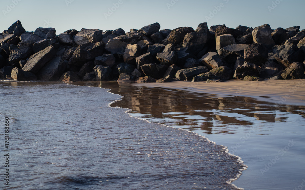 Obraz premium A view of a rocky beach at sunset, with the sea in the background Tenerife, Spain.