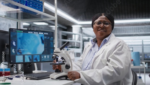 Black female expert analyzing samples in chemistry lab with microscope and observation tools. Scientist advancing genetics research, pathology analysis with biochemistry studies.